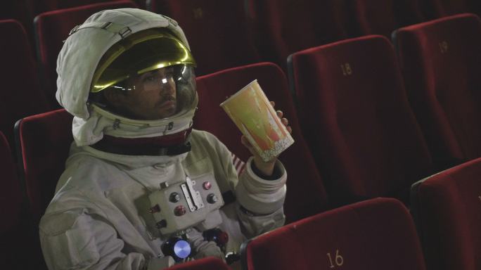 一名宇航员一边吃爆米花一边看电影