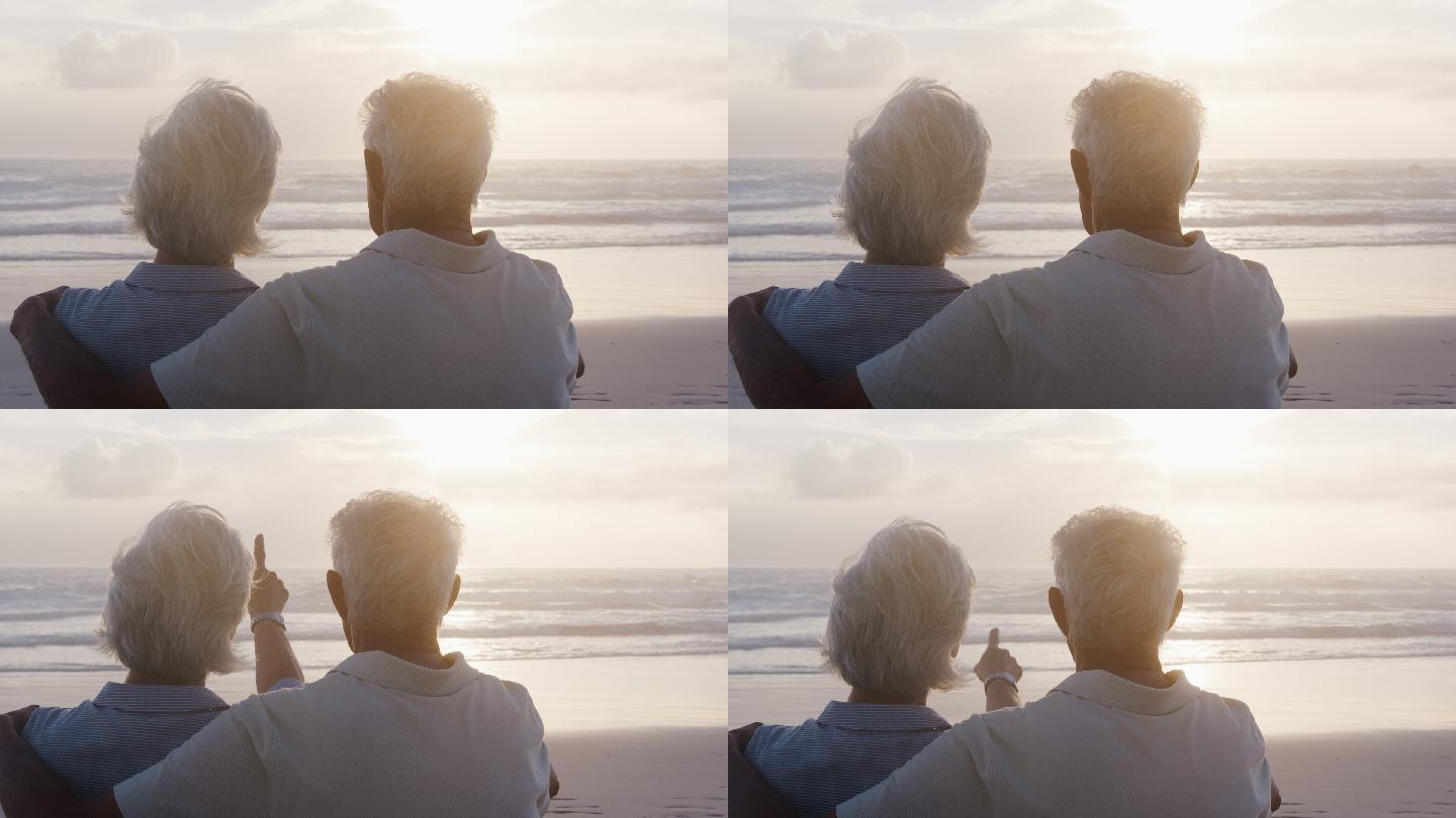 在海滩上观看日落的老年夫妇