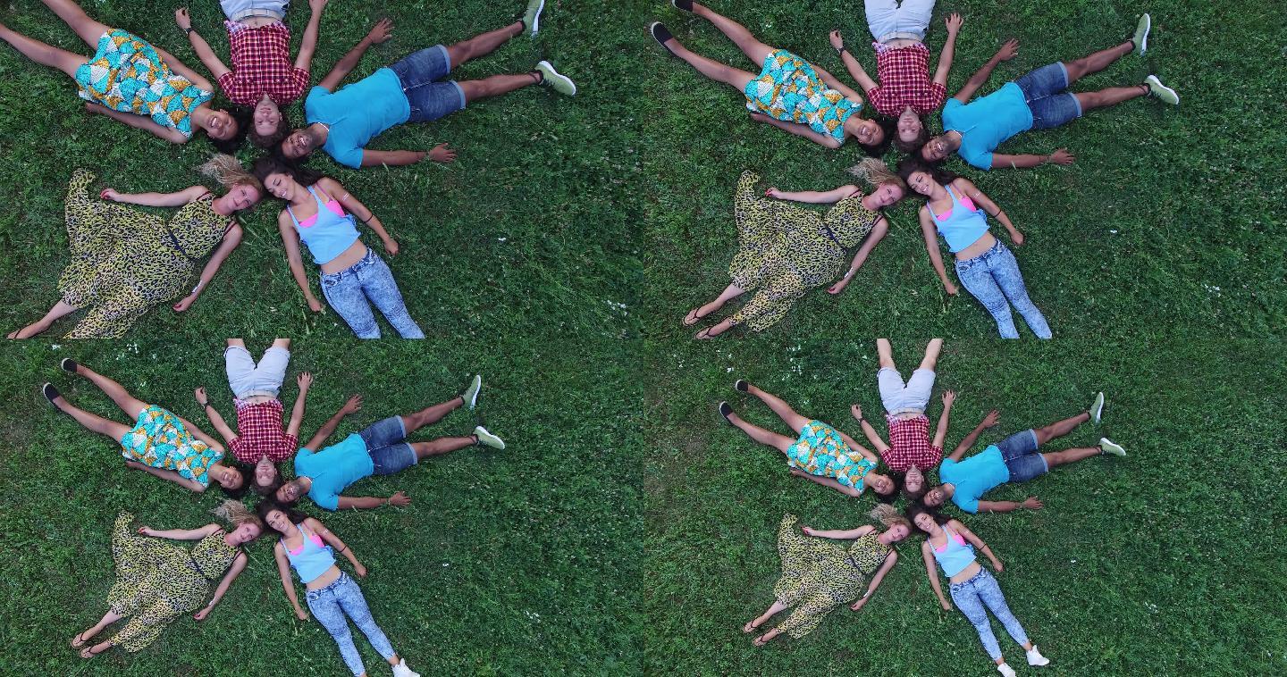 朋友们躺在草地上形成了一个星形