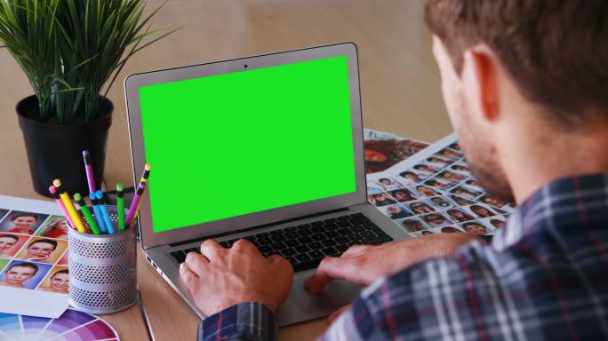 平面设计师在绿幕电脑上工作