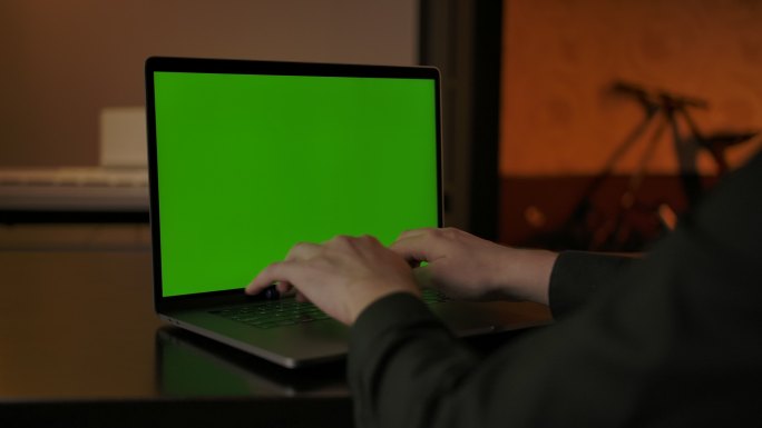 在绿色屏幕的笔记本电脑上打字