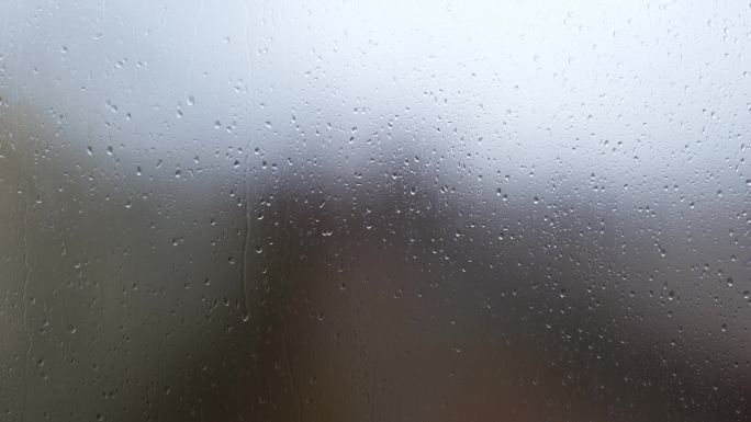 雨滴落在雾蒙蒙的玻璃