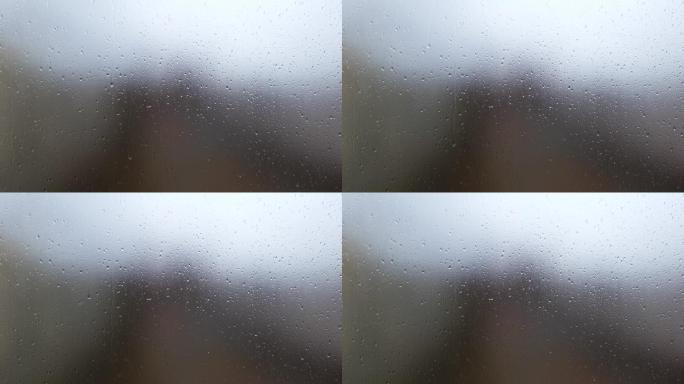 雨滴落在雾蒙蒙的玻璃
