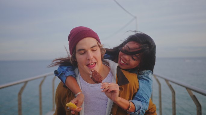 情侣在码头上吃冰淇淋玩得很开心