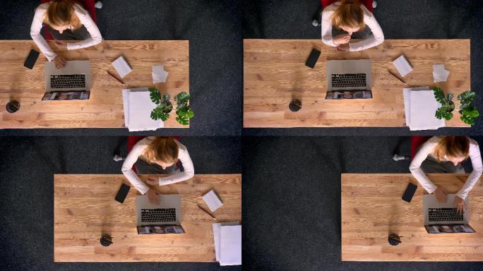 红发女子在办公室使用笔记本电脑