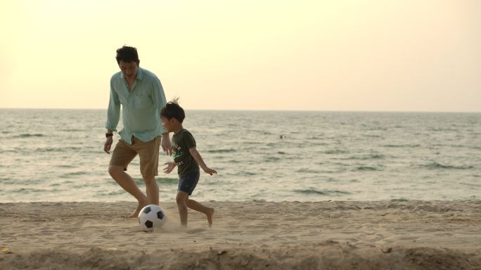父子在海滩上玩足球