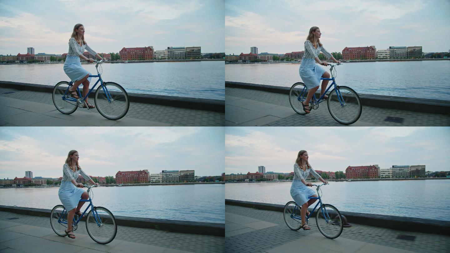 在城市滨水区骑自行车的女人
