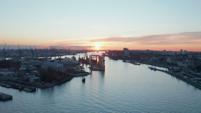 日落时，汉堡港工业区的仓库与远处的货运港