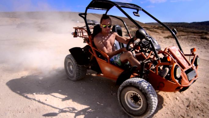 在沙漠里驾驶越野赛车的男人