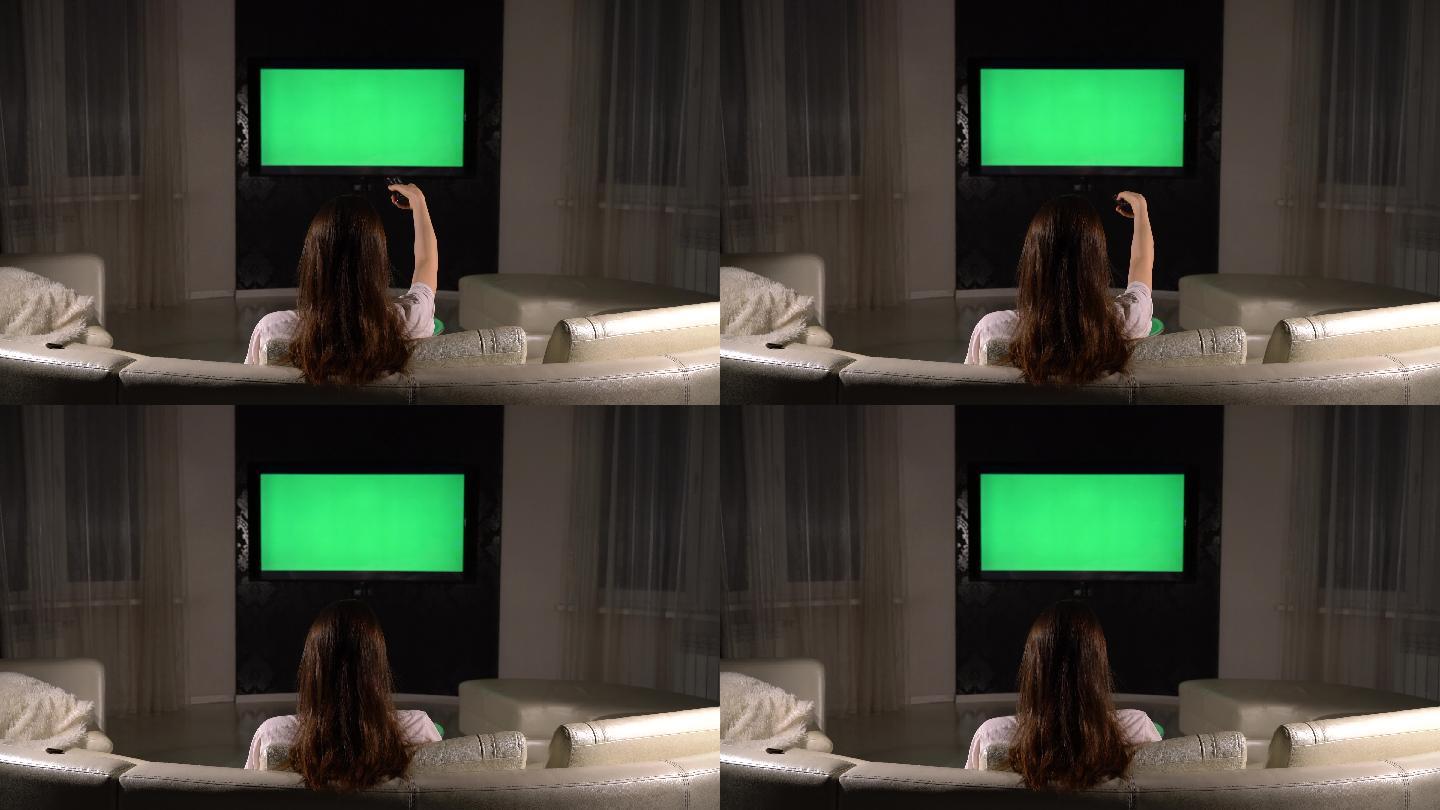 女孩在房间里看绿色屏幕的电视
