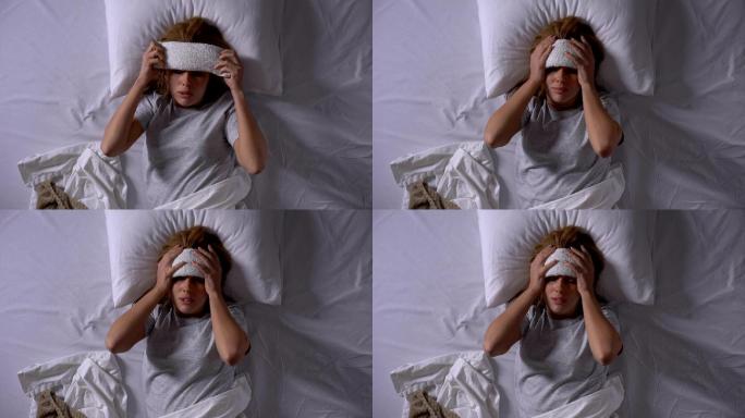 女病人在额头上敷敷布以降低体温和头痛