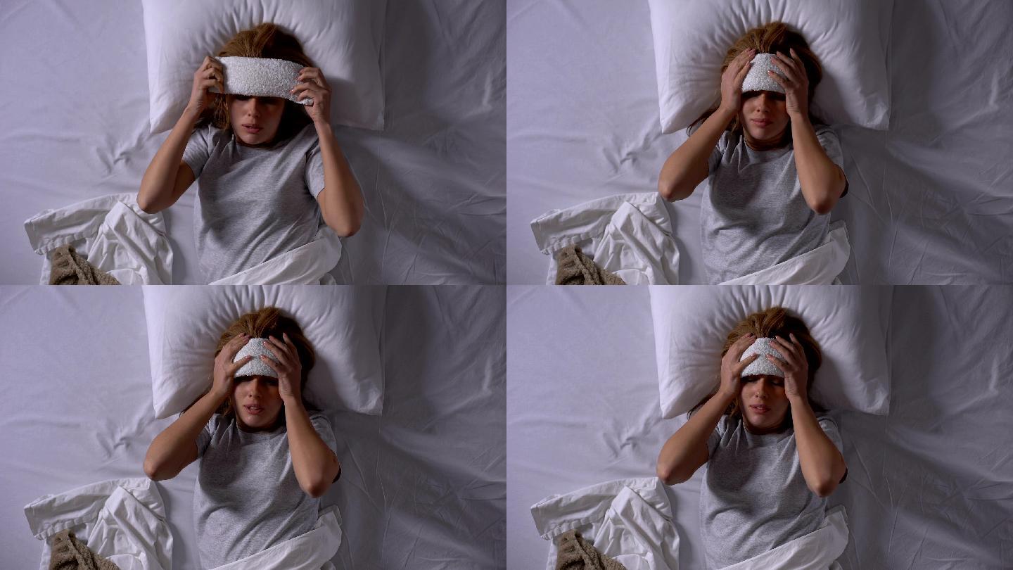 女病人在额头上敷敷布以降低体温和头痛