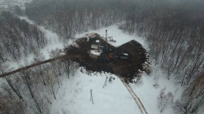 在冬季森林的一个油气田用钻机钻一口深井