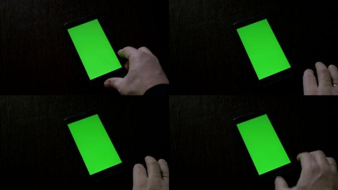 使用一部放在桌上的绿色屏幕智能手机