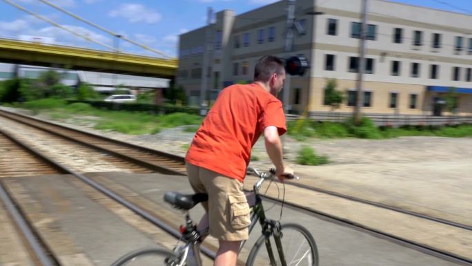 骑自行车的人穿过铁轨