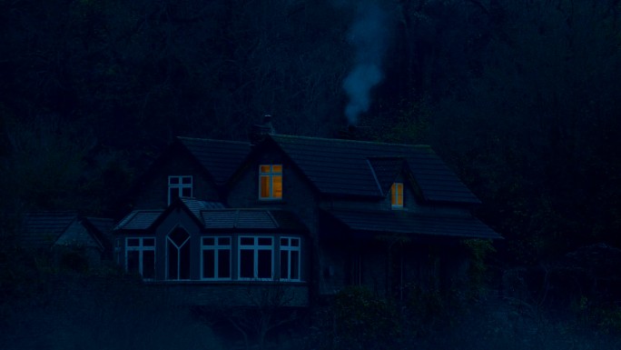 黄昏时树林中房子炊烟袅袅的房子