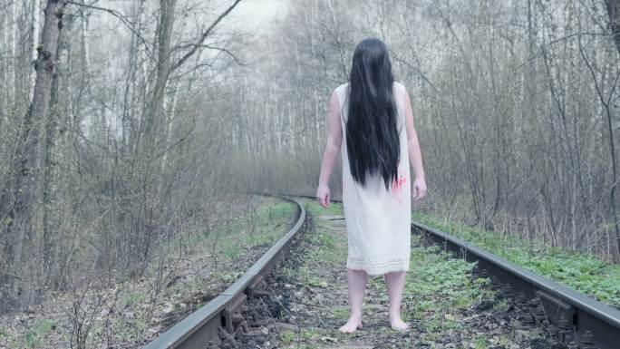 女鬼站在铁轨上的森林里