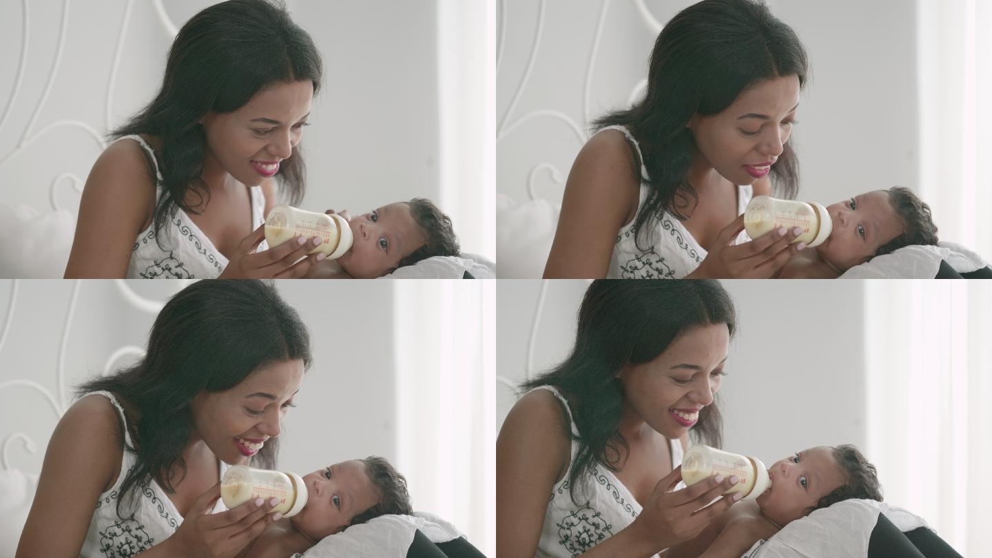 母亲用奶瓶给新生儿喂奶