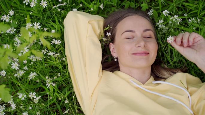 美丽的年轻女子躺在草地上