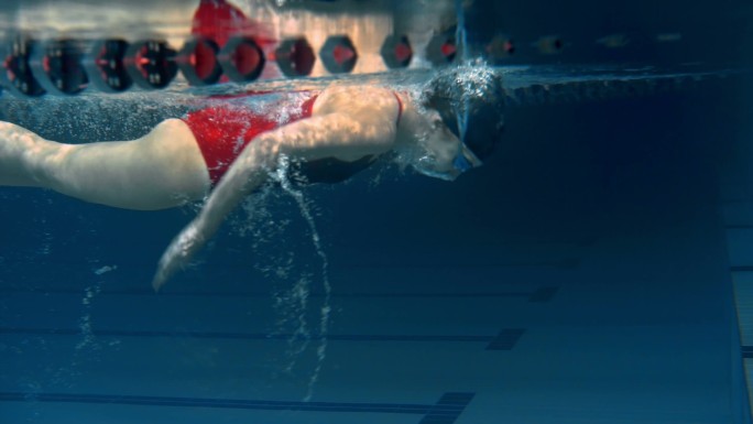 一名女子在游泳池里做翻转动作