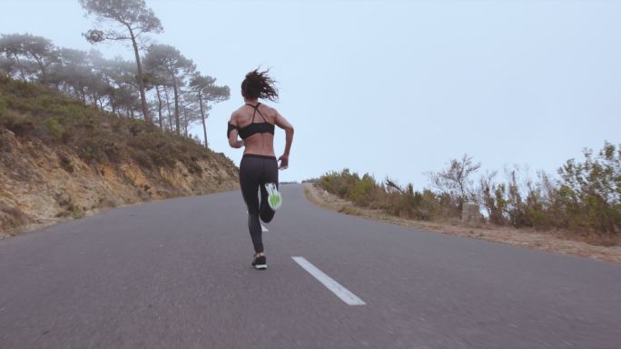 健身女子在乡村公路上疾跑