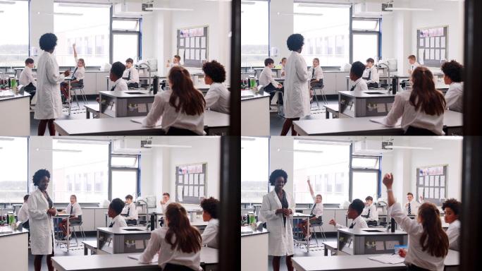 在科学课上，教师教坐在工作台上的学生