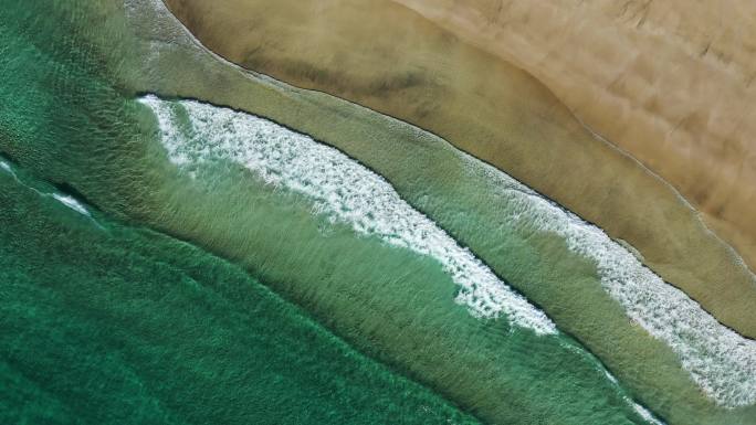 航拍绿色的海水冲击着沙滩