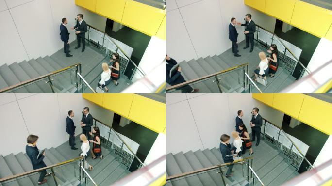 一群男女在办公中心的楼梯上走来走去