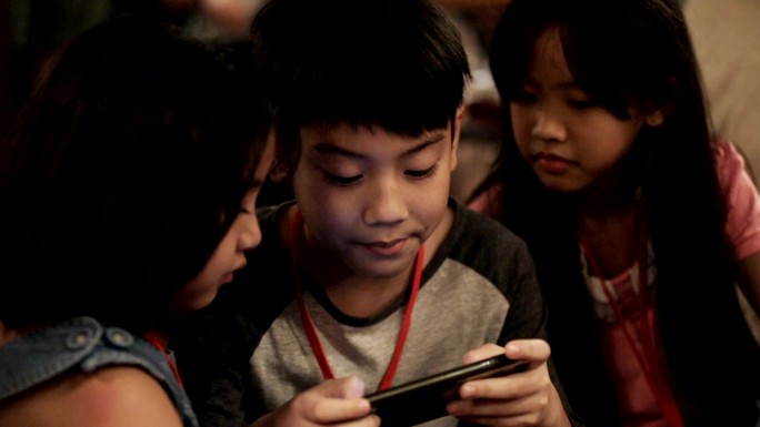 一群小孩一起玩智能手机