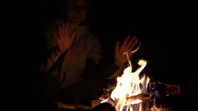 女孩在明火旁暖手取暖烧火烤火