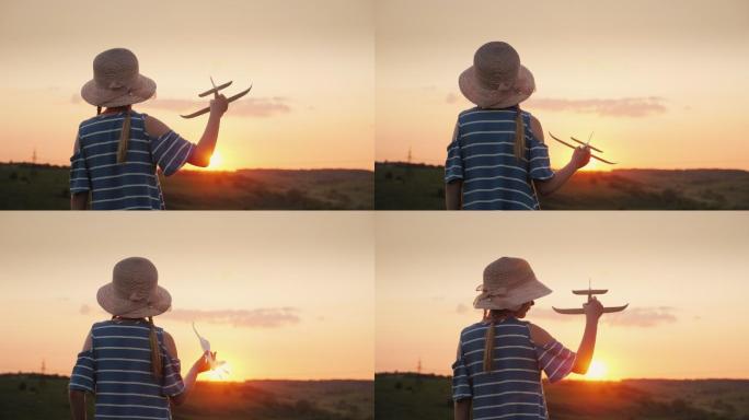 一个女孩在日落时玩一架木制飞机。