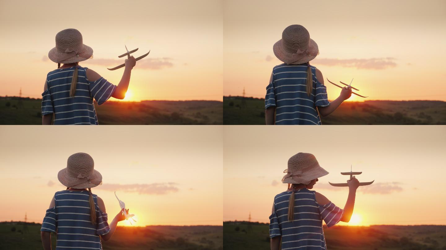 一个女孩在日落时玩一架木制飞机。