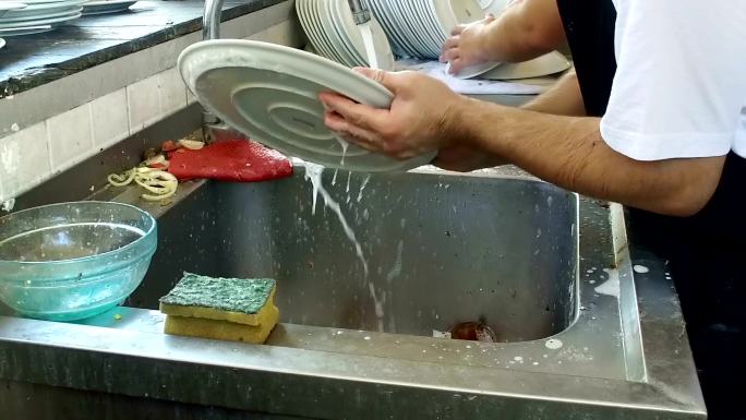 在厨房清洗脏盘子的人特写慢镜头