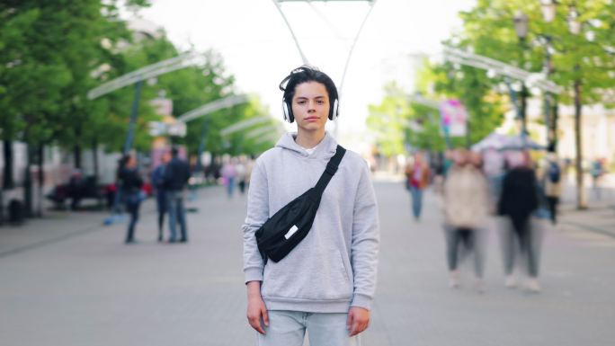 戴着耳机的少年站在街上的延时摄影