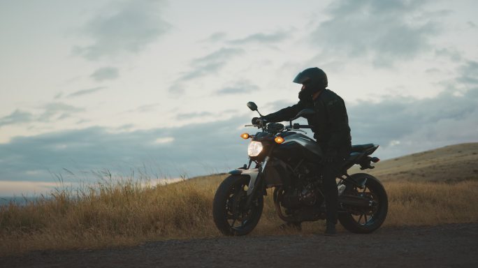 骑摩托车的人在夕阳下看风景