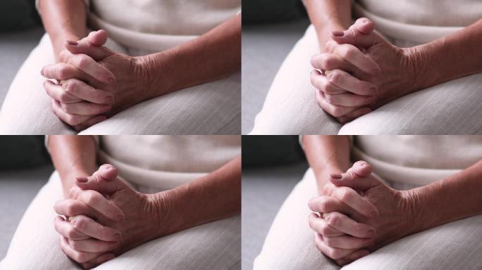 老年女性双手合十祈祷的特写镜头