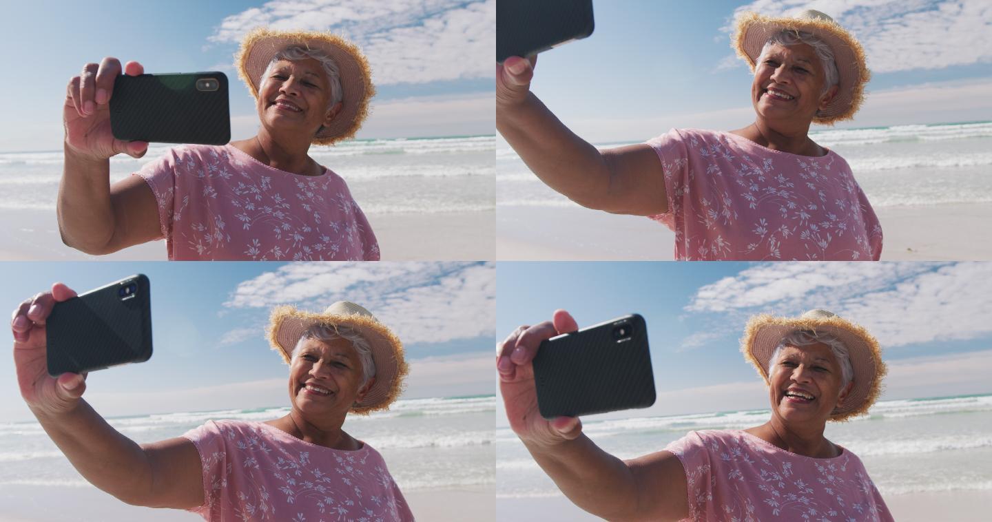 老年女性在海滩用智能手机自拍