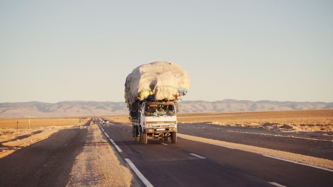 沙漠路上满载麻袋的卡车