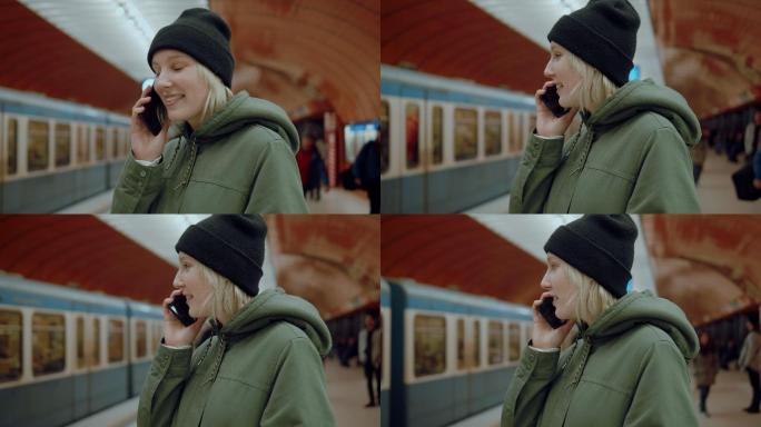 一位女孩在地铁站讲着电话，火车在后台经过。