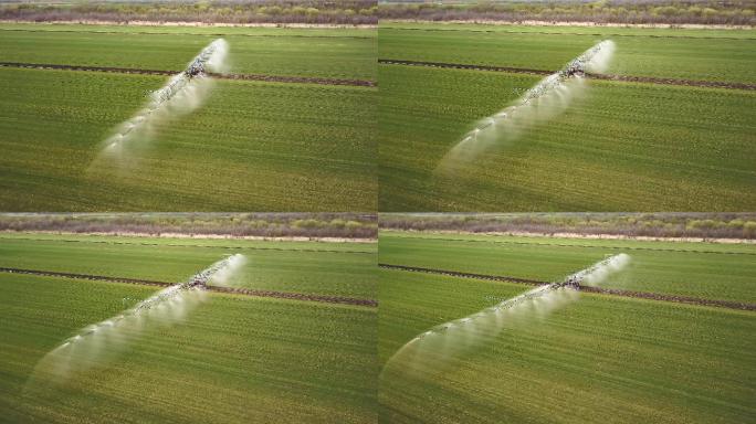 一架农用拖拉机喷洒农田的空中无人机镜头。