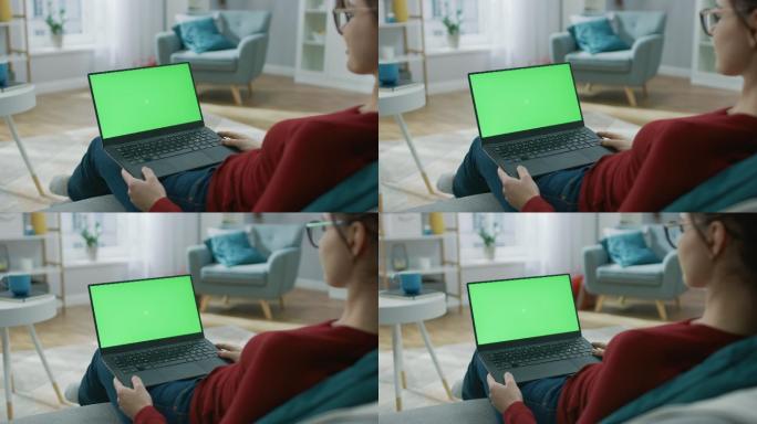 女孩在家浏览绿色屏幕的电脑