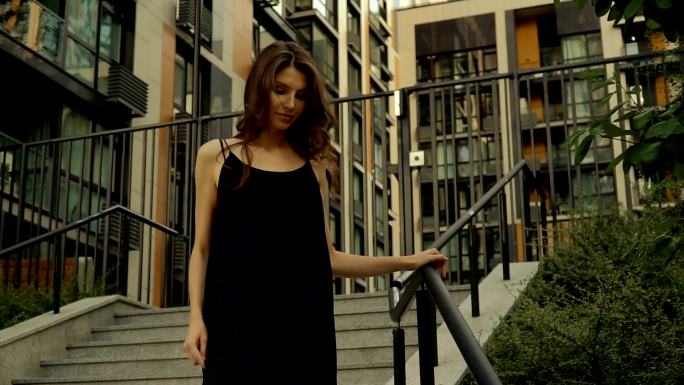 一个穿黑衣服的女孩从城市楼梯上下来