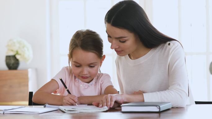 妈妈帮助女儿做家庭作业