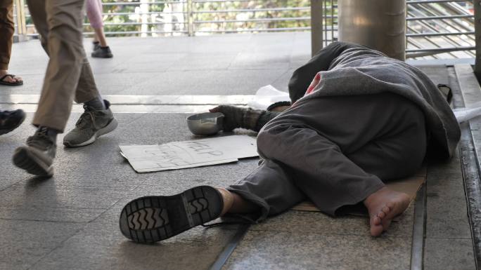 无家可归的老人穿着脏衣服睡在街上