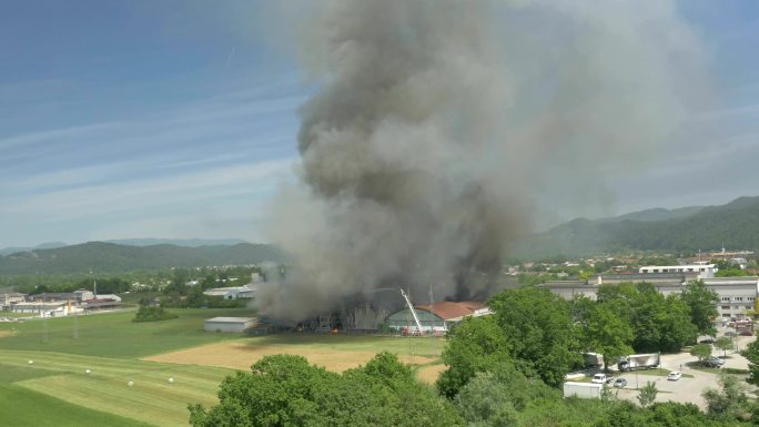 空中：消防员试图扑灭农村正在燃烧的工厂的大火