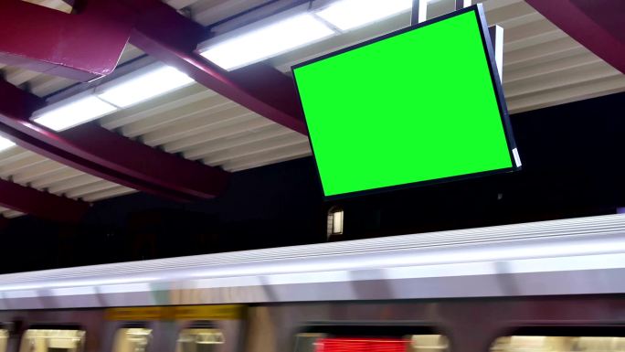 夜间地铁站台上的绿色屏幕交通板