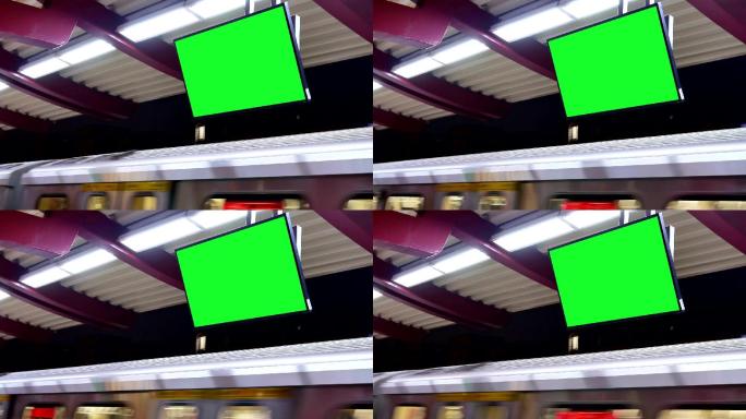 夜间地铁站台上的绿色屏幕交通板