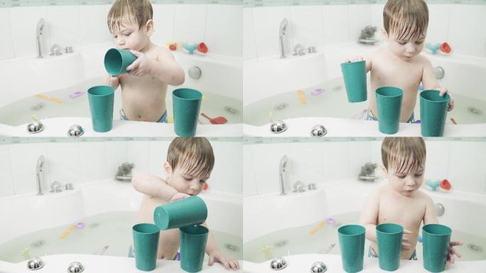 浴室里的小男孩在用杯子玩水