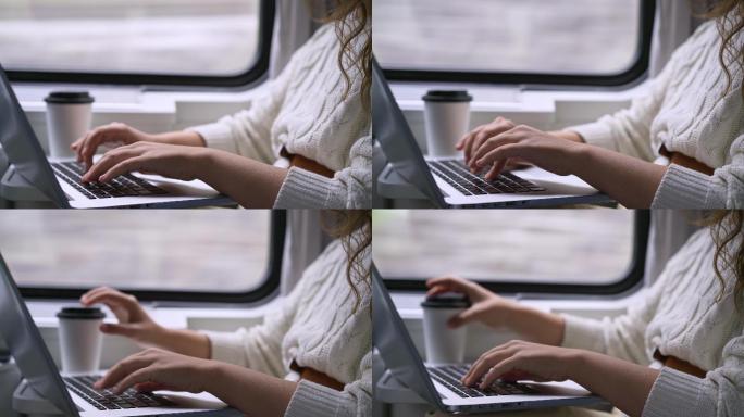 坐在窗户边上用电脑工作的女人
