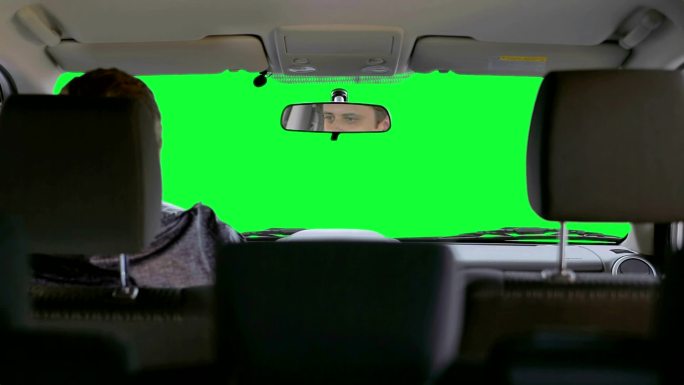 一名男子在绿色背景下驾驶汽车
